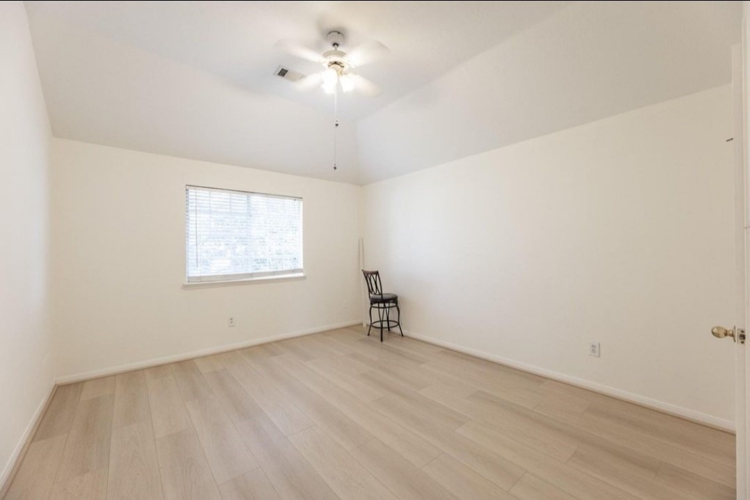 2515 Falcon Ridge Street Pearland, TX 77584 - Photo 28 of 31 wooden floor in an empty room with a window