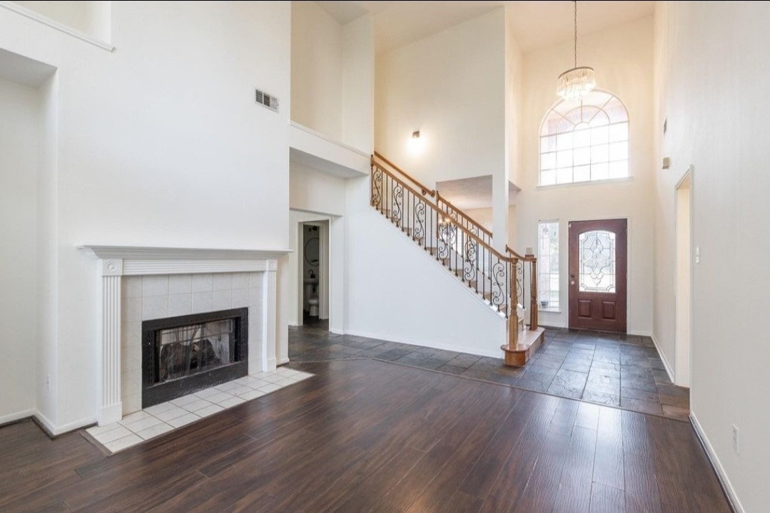 2515 Falcon Ridge Street Pearland, TX 77584 - Photo 9 of 31 a view of an empty room with wooden floor fireplace and a window