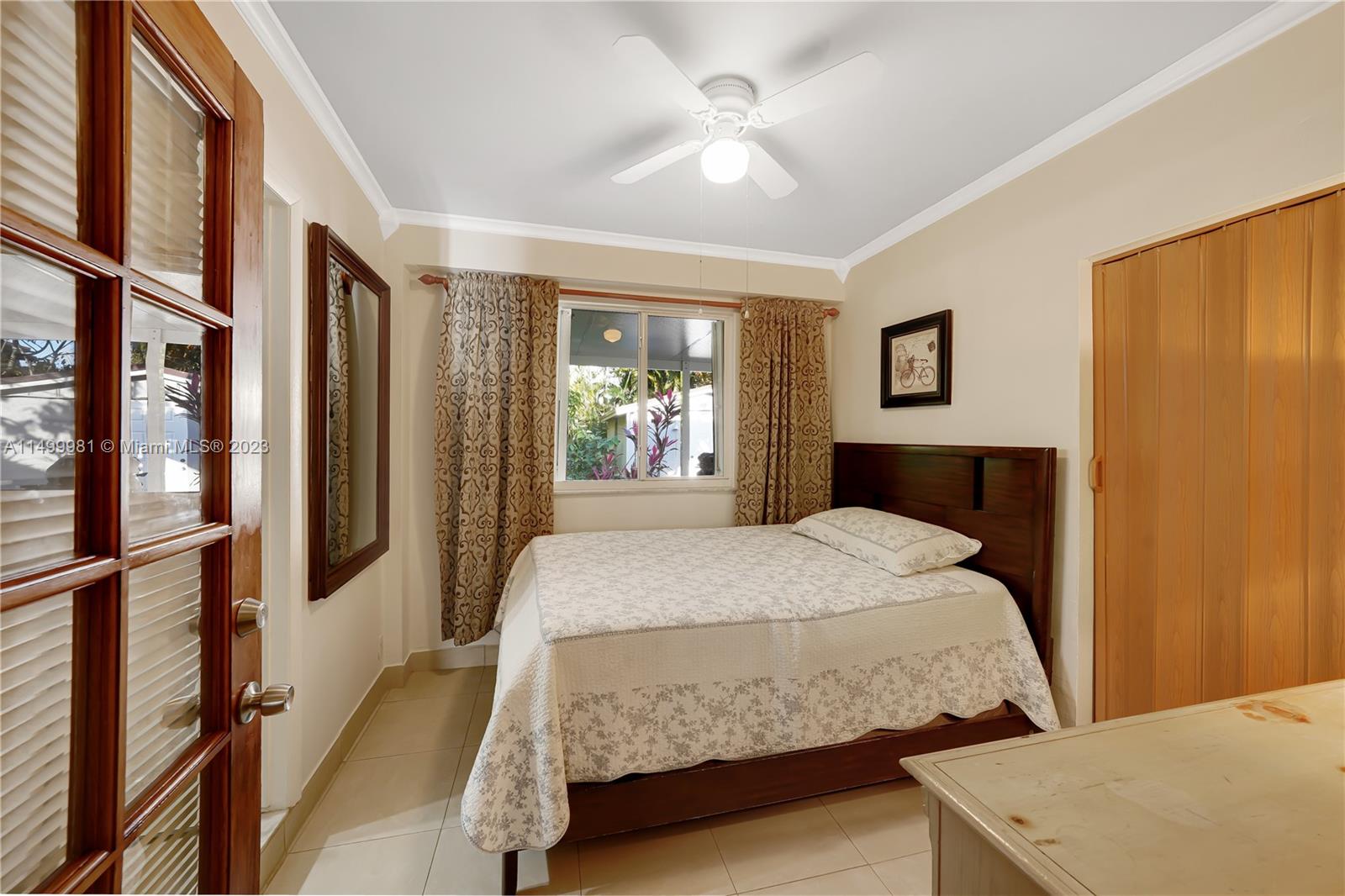 2755 Southwest 33rd Court Miami, FL 33133 - Photo 10 of 22 a bedroom with a large bed and a chandelier