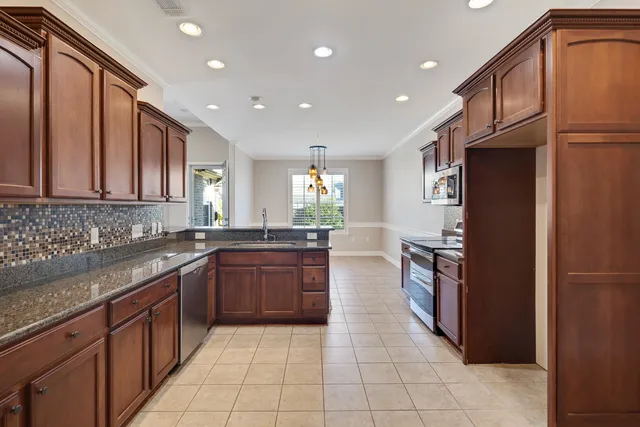a kitchen with stainless steel appliances granite countertop a refrigerator and a sink