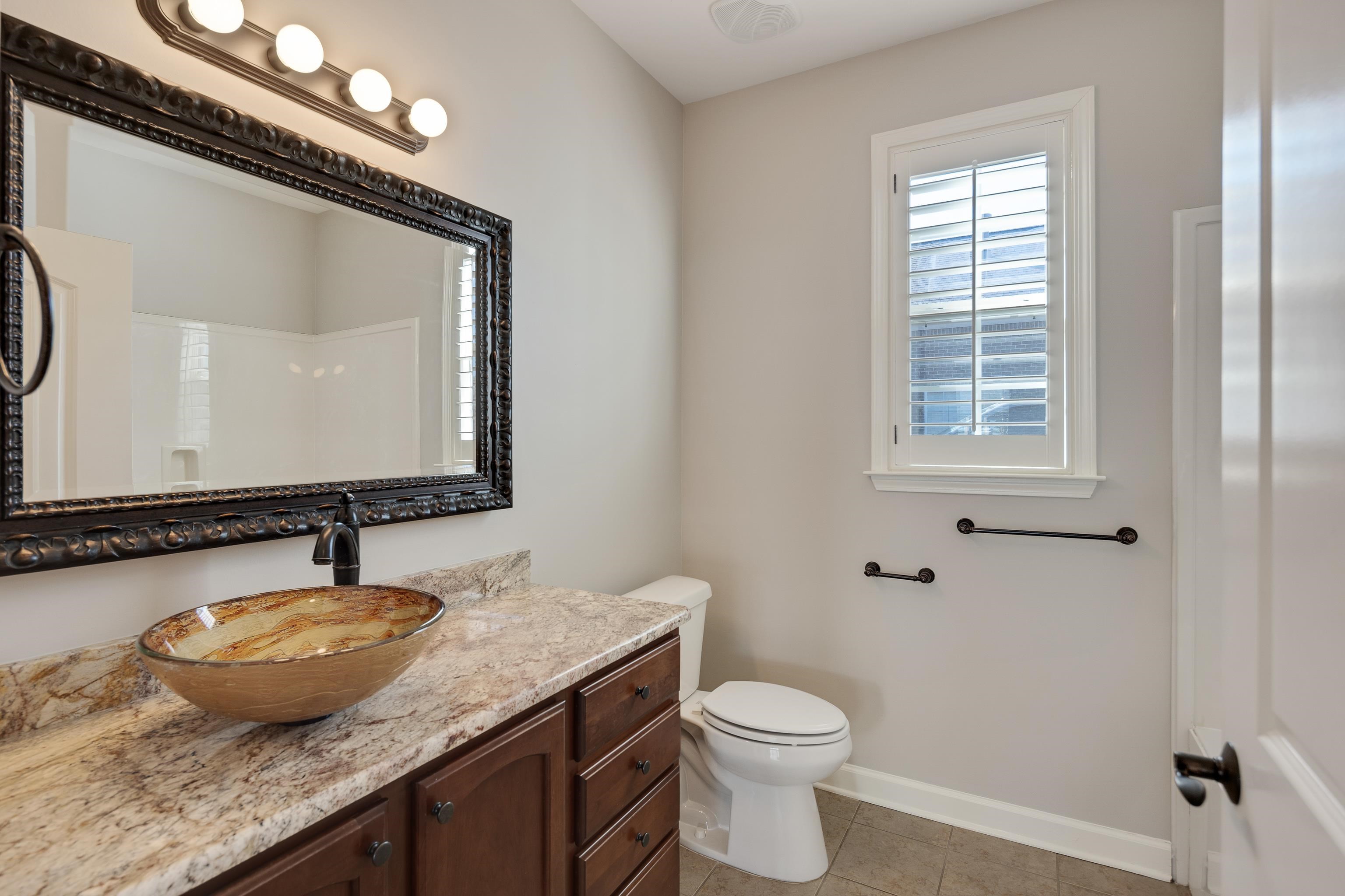 1422 Calumet Farms Drive, Unit 7 Collierville, TN 38017 - Photo 26 of 29 a bathroom with a granite countertop sink a toilet and mirror