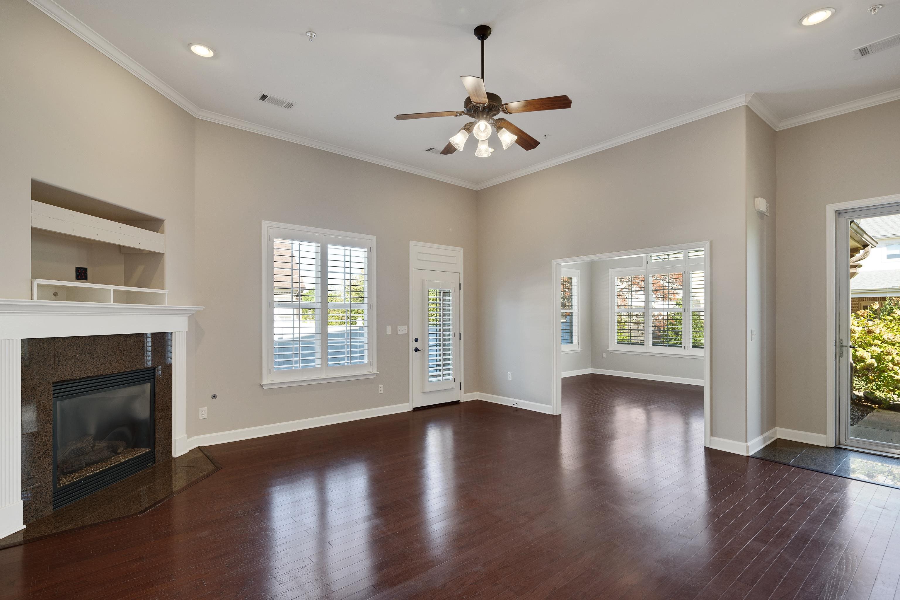 1422 Calumet Farms Drive, Unit 7 Collierville, TN 38017 - Photo 9 of 29 a view of an empty room with wooden floor fireplace and a window