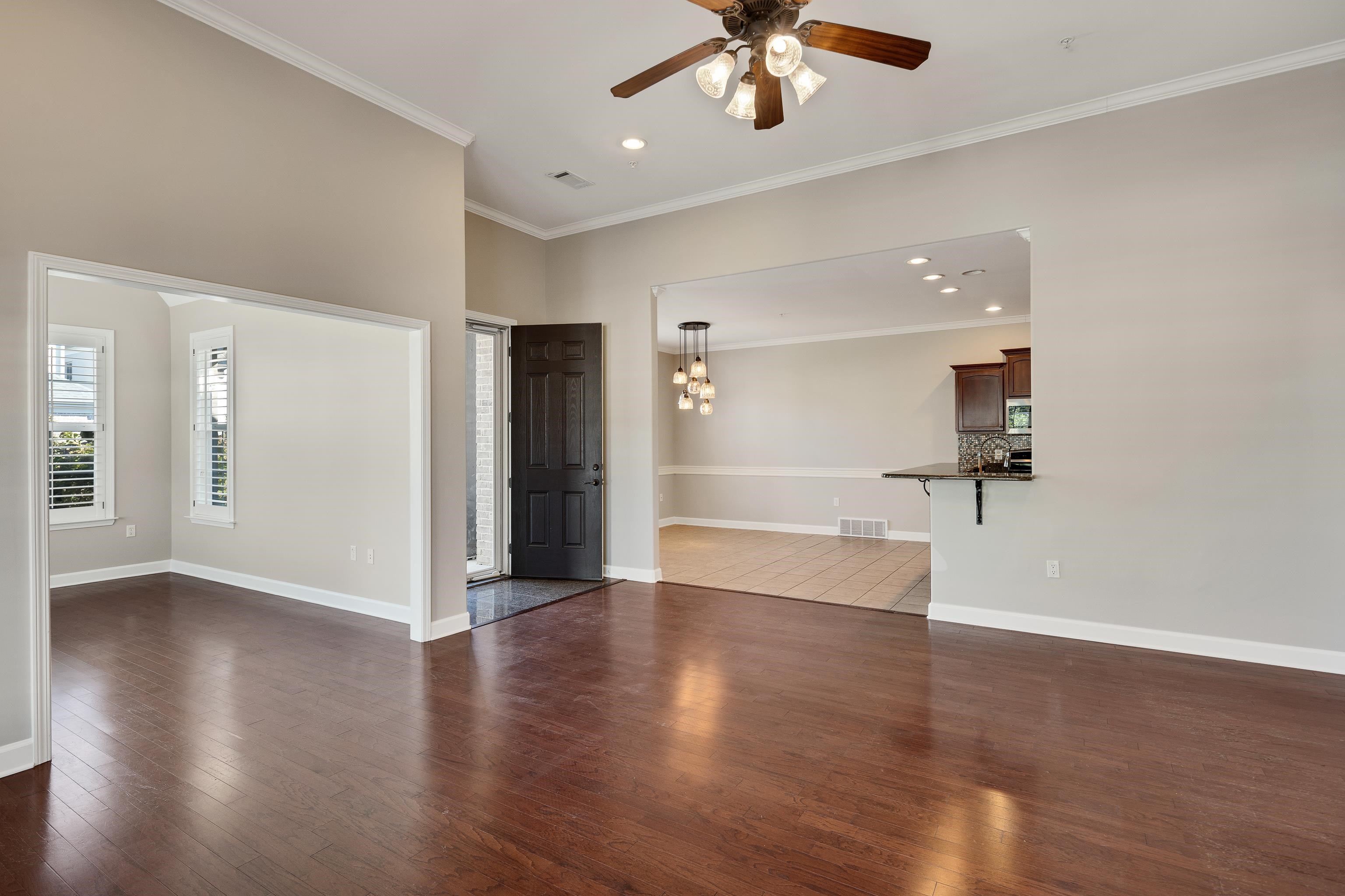 1422 Calumet Farms Drive, Unit 7 Collierville, TN 38017 - Photo 10 of 29 a view of an empty room with wooden floor and a ceiling fan