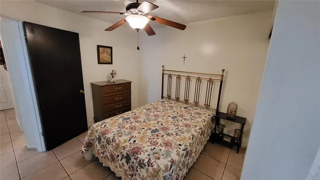 a bedroom with a bed and a flat tv screen on a dresser