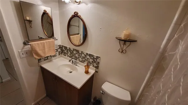 a bathroom with a sink toilet and a mirror