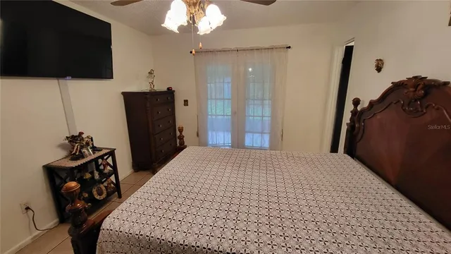 a bedroom with a bed and a flat tv screen on the dresser