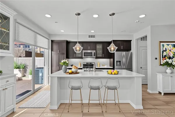 a living room with furniture kitchen view and a chandelier