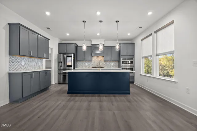 a kitchen with stainless steel appliances kitchen island granite countertop a large counter top space a sink stainless steel appliances and cabinets