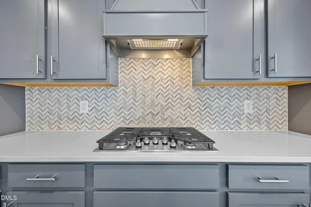 a large kitchen with a large counter top a sink stainless steel appliances and cabinets