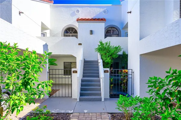 a front view of a house with plants and entryway