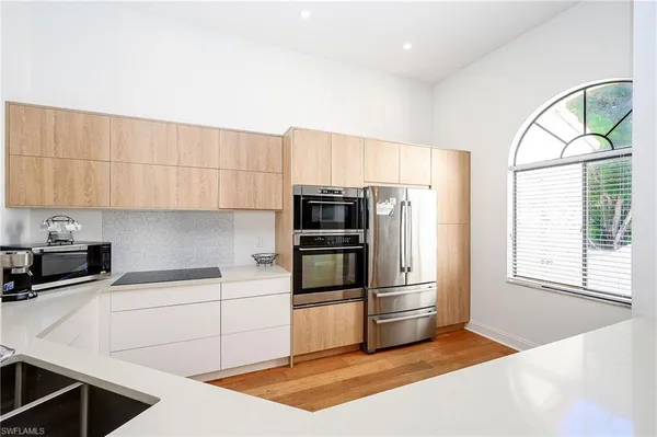 a kitchen with granite countertop a refrigerator oven a sink and dishwasher