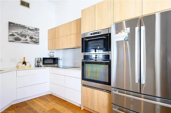 a kitchen with stainless steel appliances a refrigerator sink and microwave
