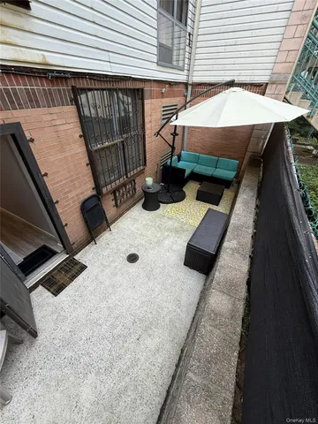 a balcony with furniture and a umbrella