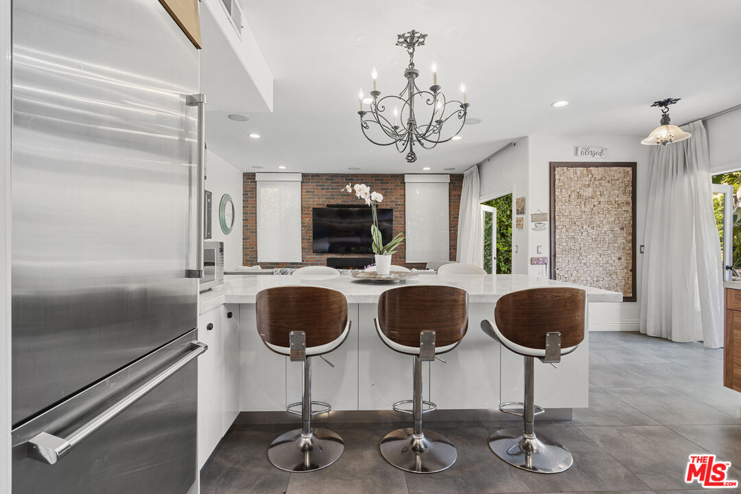 4544 Tobias Avenue Sherman Oaks, CA 91403 - Photo 27 of 55 a kitchen with granite countertop a table chair and chandelier