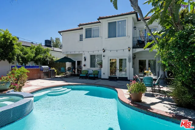 a front view of a house with swimming pool fire pit and outdoor seating