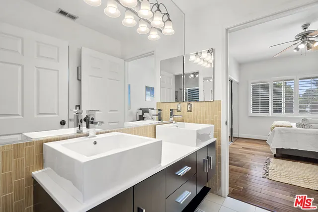 a bedroom with a bed chair and wooden floor