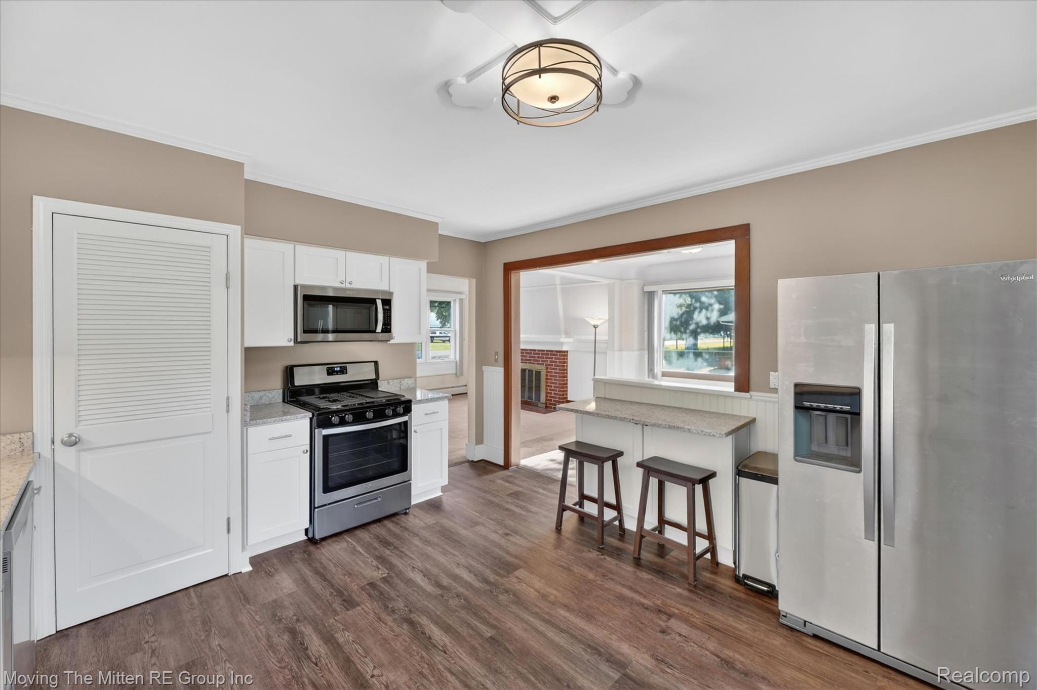 25505 Wick Road Taylor, MI 48180 - Photo 11 of 68 Kitchen with stainless steel appliances, ornamental molding, white cabinetry, dark wood-style floors, and light stone countertops