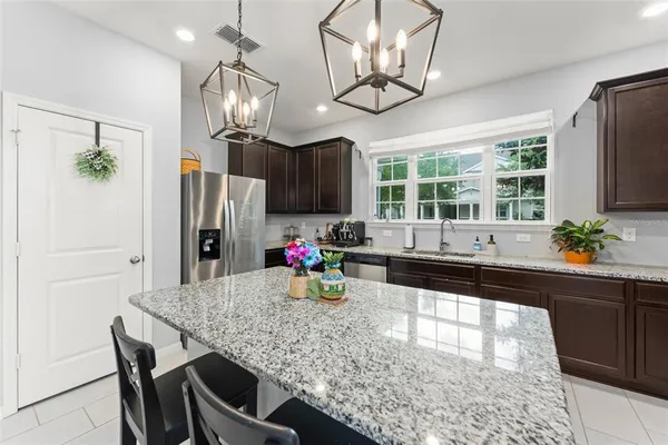 a kitchen with stainless steel appliances granite countertop a sink refrigerator stove and microwave