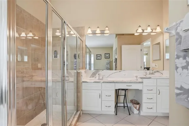 a bathroom with a sink vanity granite shower and a mirror