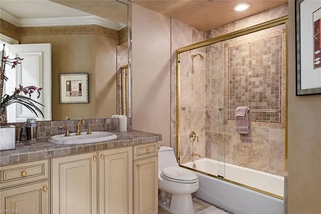 a bathroom with a granite countertop sink toilet and shower