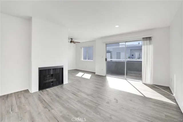 an empty room with wooden floor and natural light