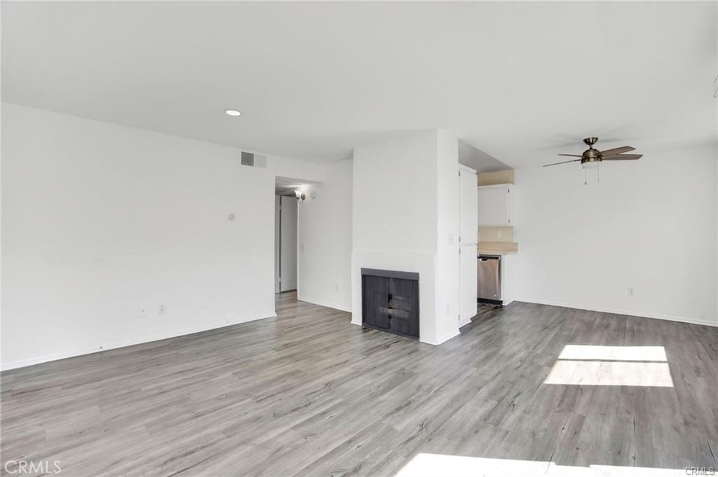 4406 Cahuenga Boulevard, Unit 202 Toluca Lake, CA 91602 - Photo 4 of 16 an empty room with wooden floor fireplace and windows