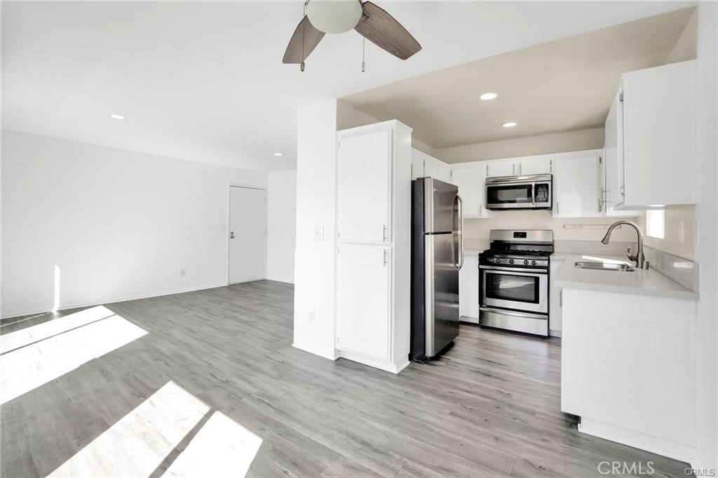 4406 Cahuenga Boulevard, Unit 202 Toluca Lake, CA 91602 - Photo 6 of 16 a kitchen with granite countertop a refrigerator and a stove top oven
