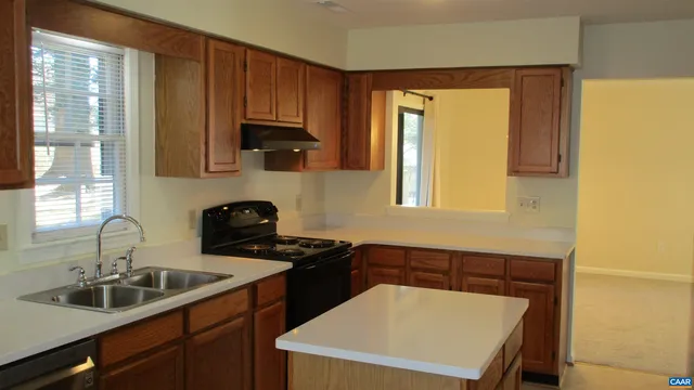 a kitchen with a sink a stove and cabinets