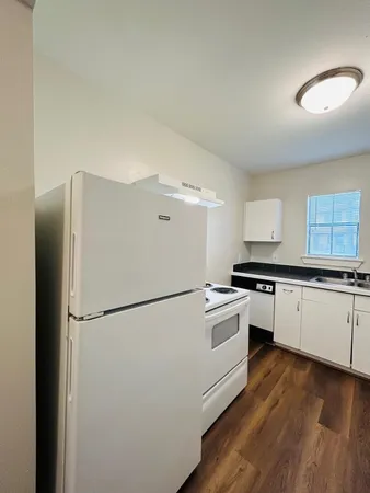 a kitchen with stainless steel appliances a refrigerator a sink and white cabinets