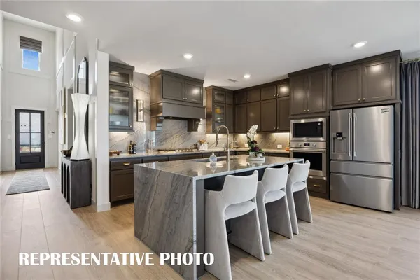a kitchen with kitchen island granite countertop lots of counter top space and stainless steel appliances