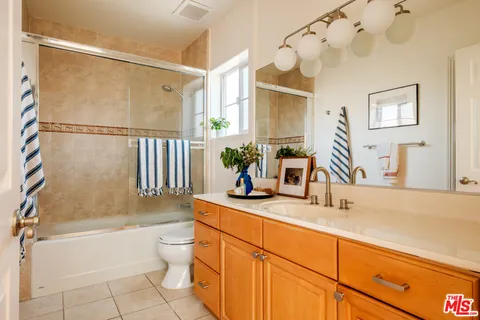 a bathroom with a granite countertop sink a toilet and shower