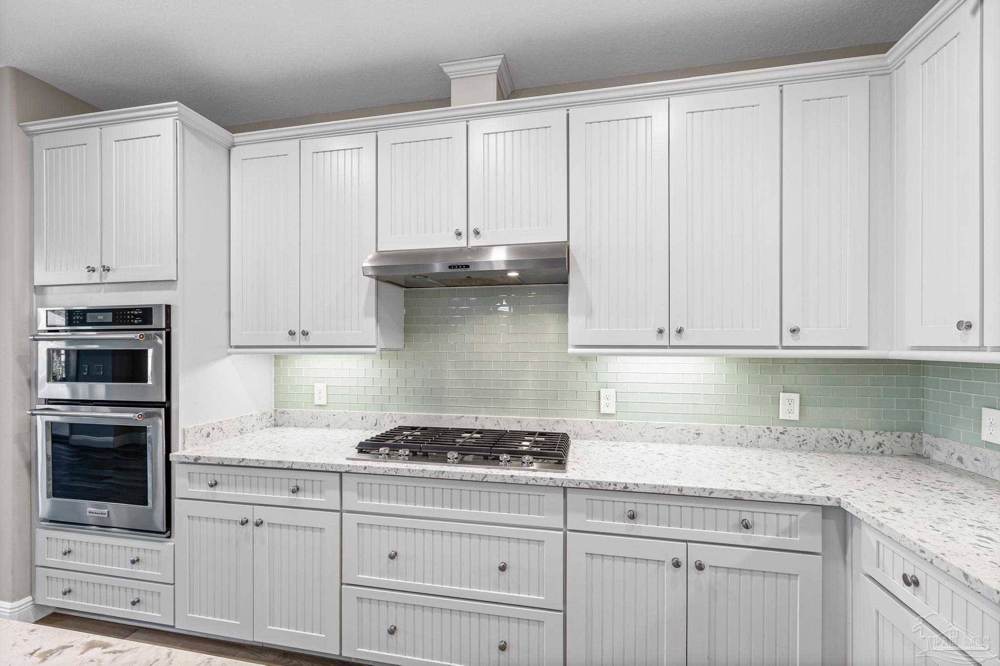 7166 Jasper Street Navarre, FL 32566 - Photo 14 of 71 a kitchen with granite countertop white cabinets and stainless steel appliances
