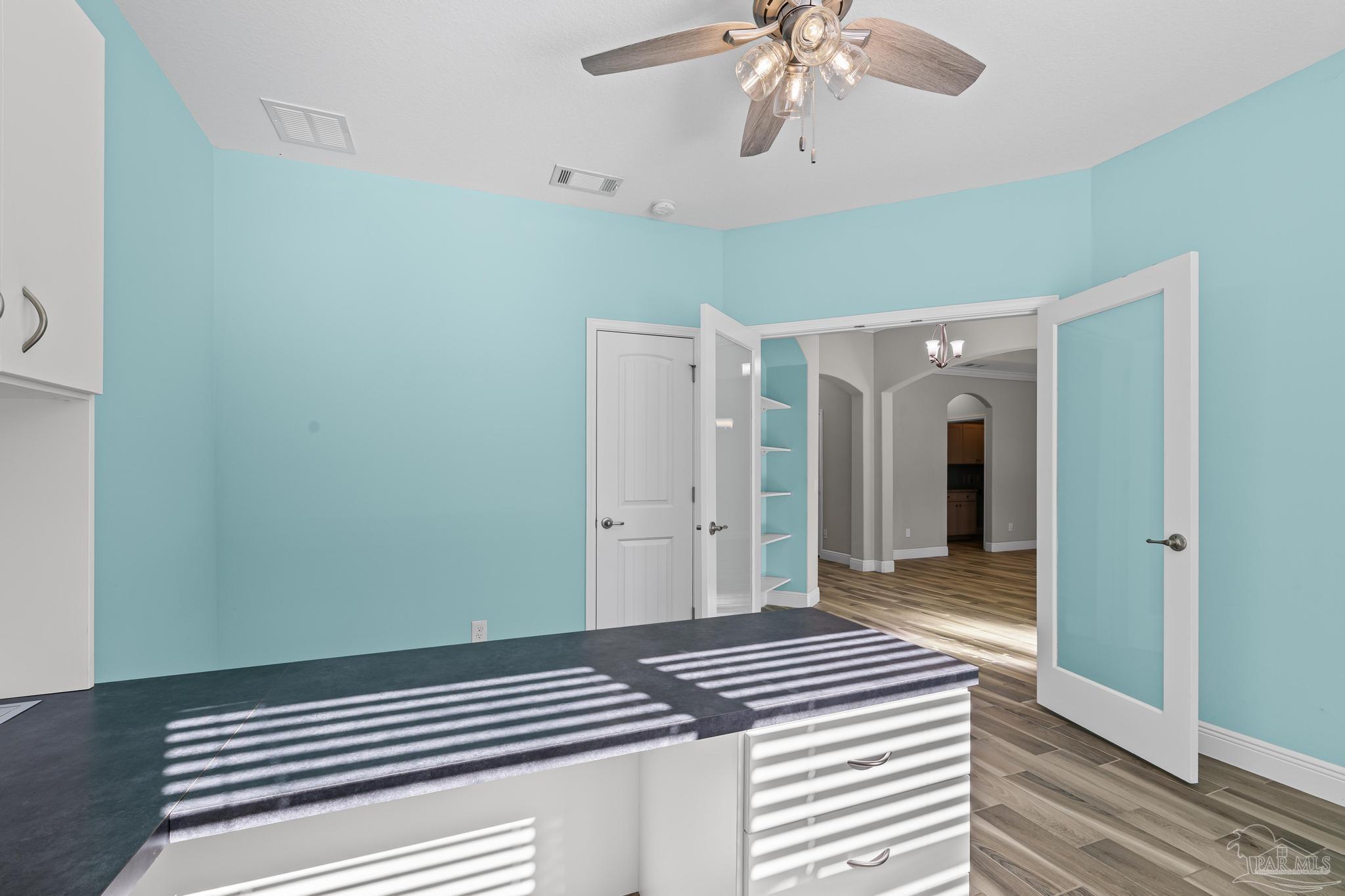 7166 Jasper Street Navarre, FL 32566 - Photo 17 of 71 a bedroom with a bed and a chandelier