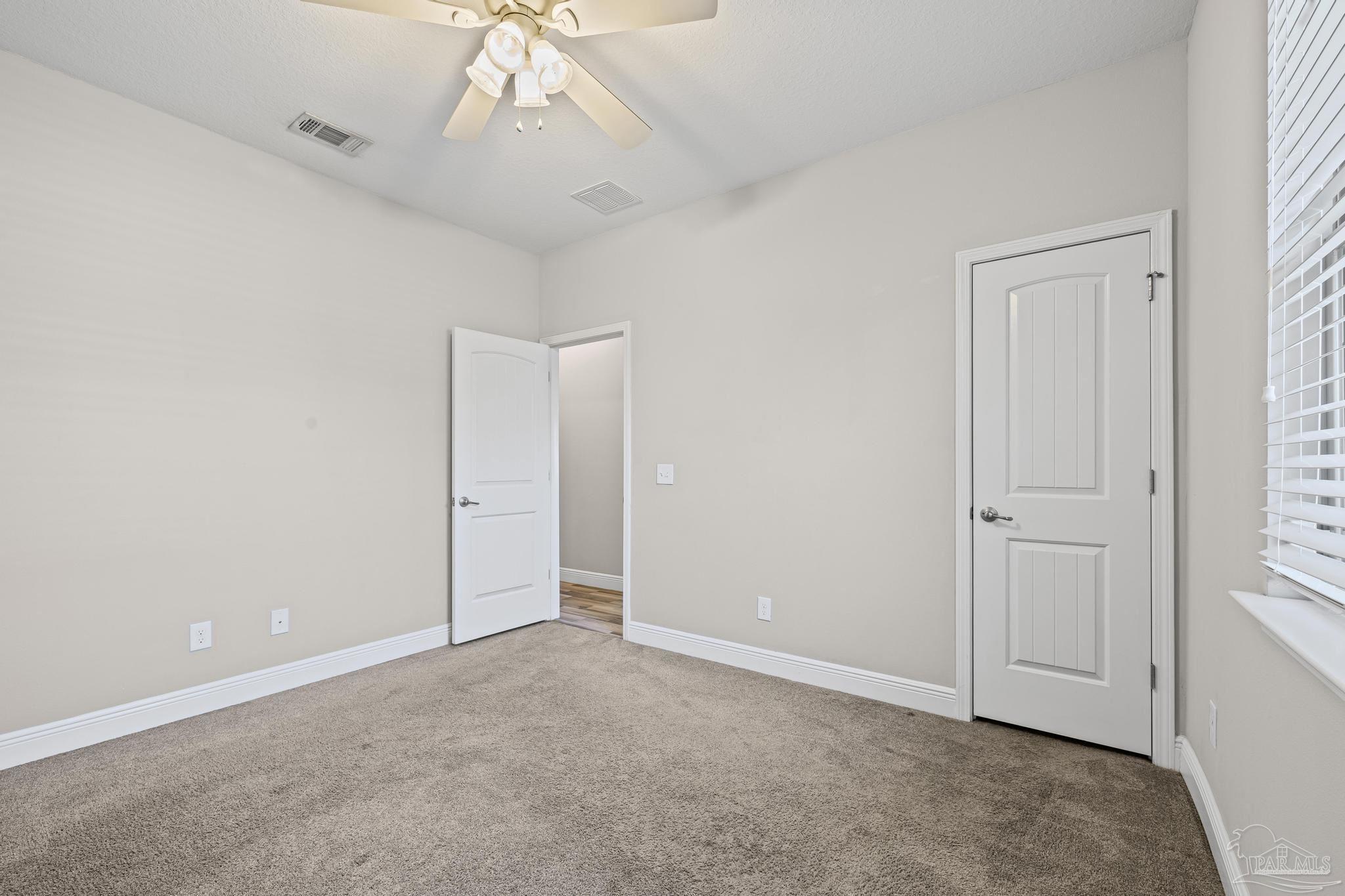 7166 Jasper Street Navarre, FL 32566 - Photo 27 of 71 an empty room with a ceiling fan and window