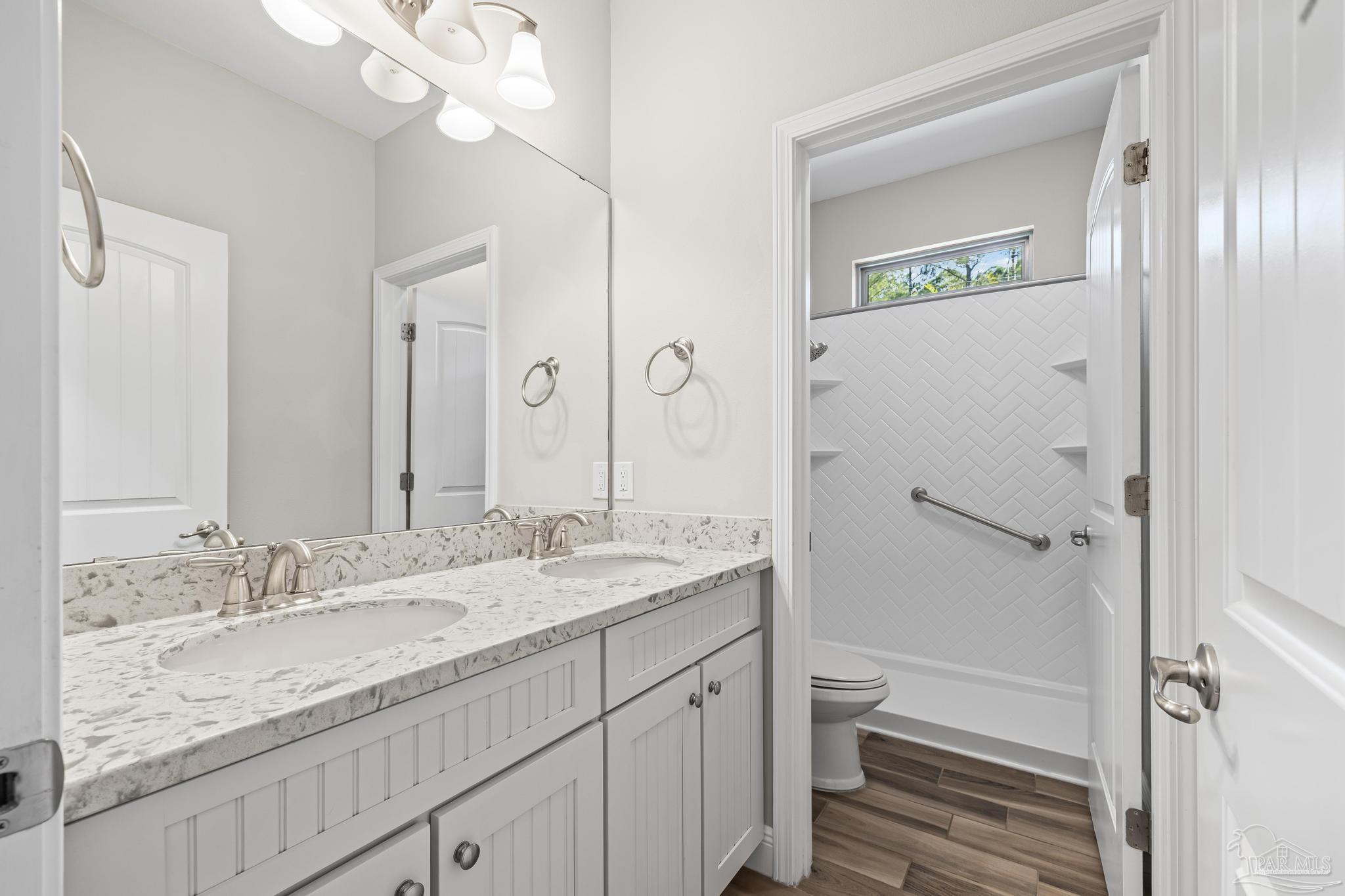 7166 Jasper Street Navarre, FL 32566 - Photo 28 of 71 a bathroom with a granite countertop sink toilet and shower