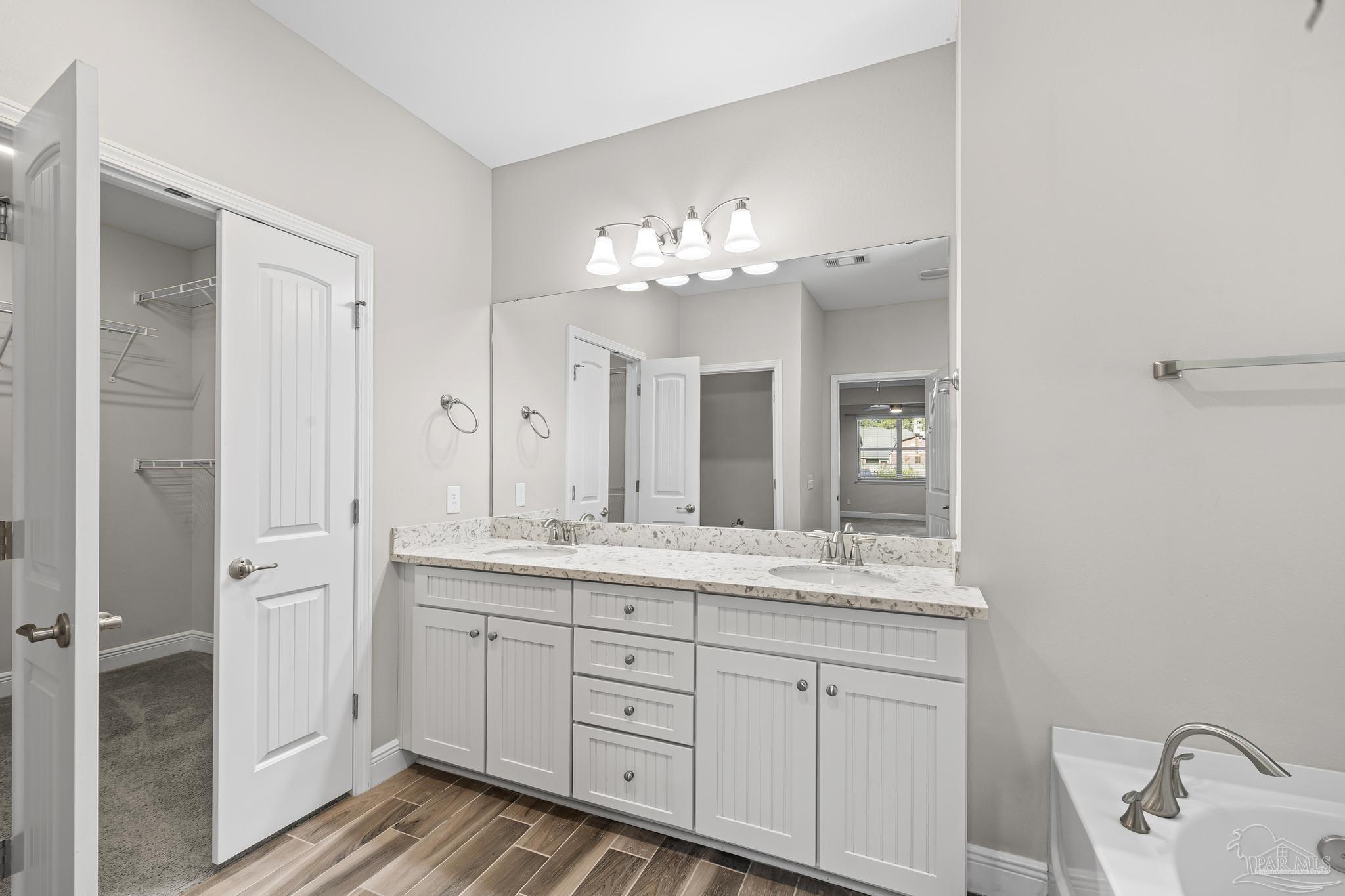 7166 Jasper Street Navarre, FL 32566 - Photo 40 of 71 a bathroom with a double vanity sink and a mirror