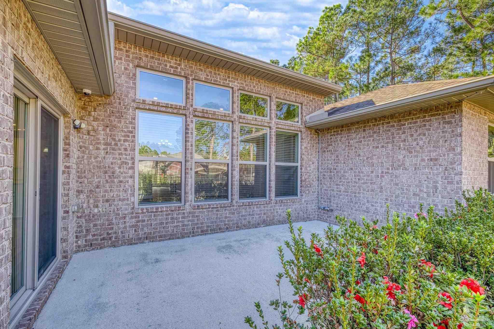 7166 Jasper Street Navarre, FL 32566 - Photo 44 of 71 a front view of a house with a garden