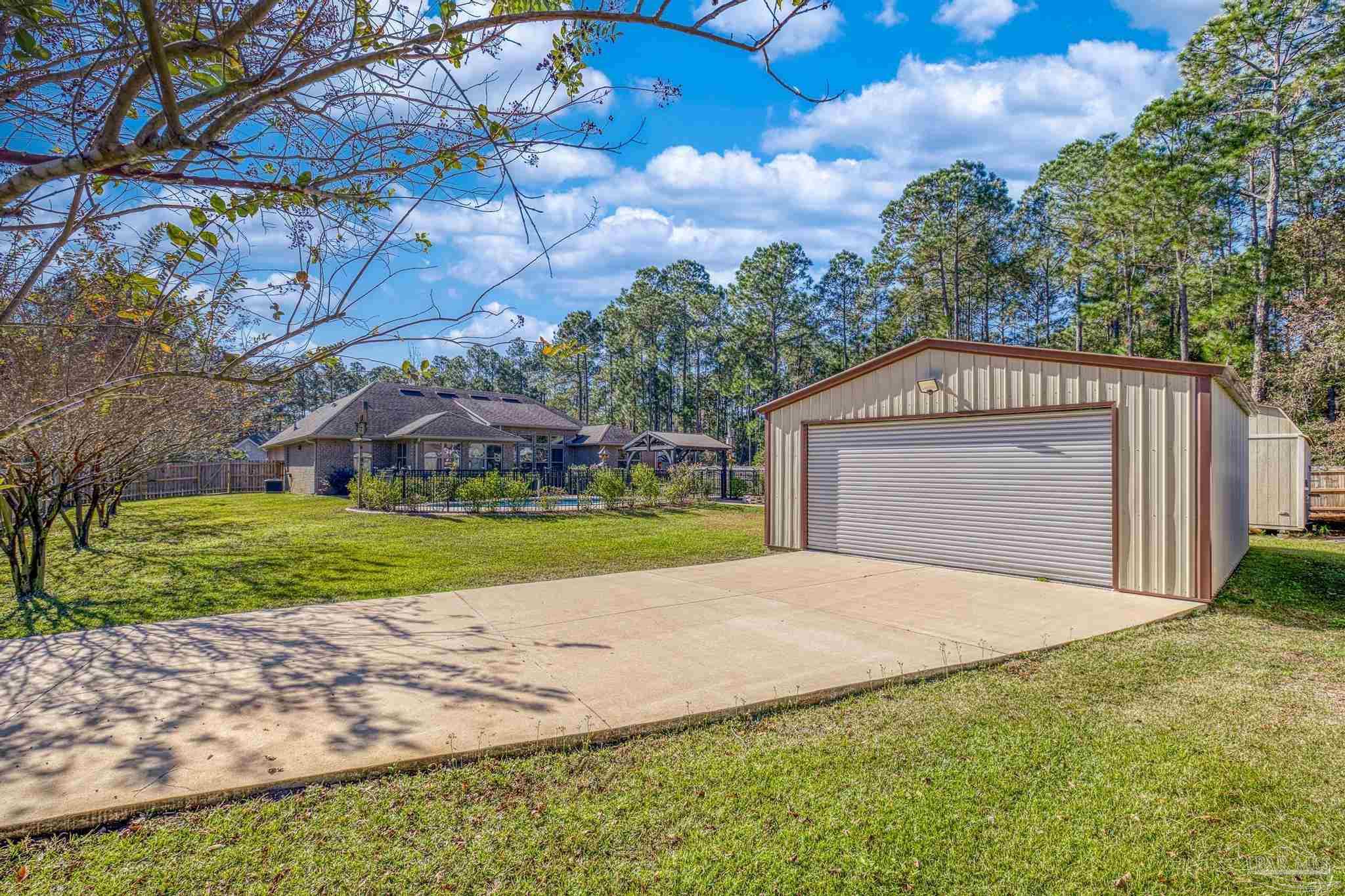 7166 Jasper Street Navarre, FL 32566 - Photo 53 of 71 a view of a house with a yard and large tree