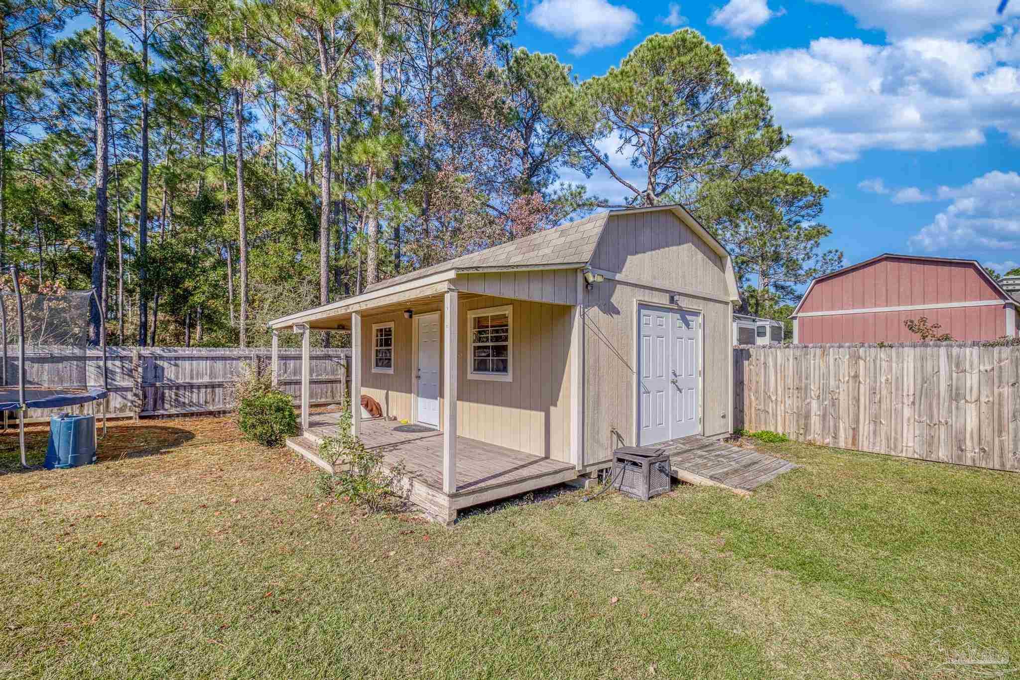 7166 Jasper Street Navarre, FL 32566 - Photo 55 of 71 a view of a house with backyard and sitting area
