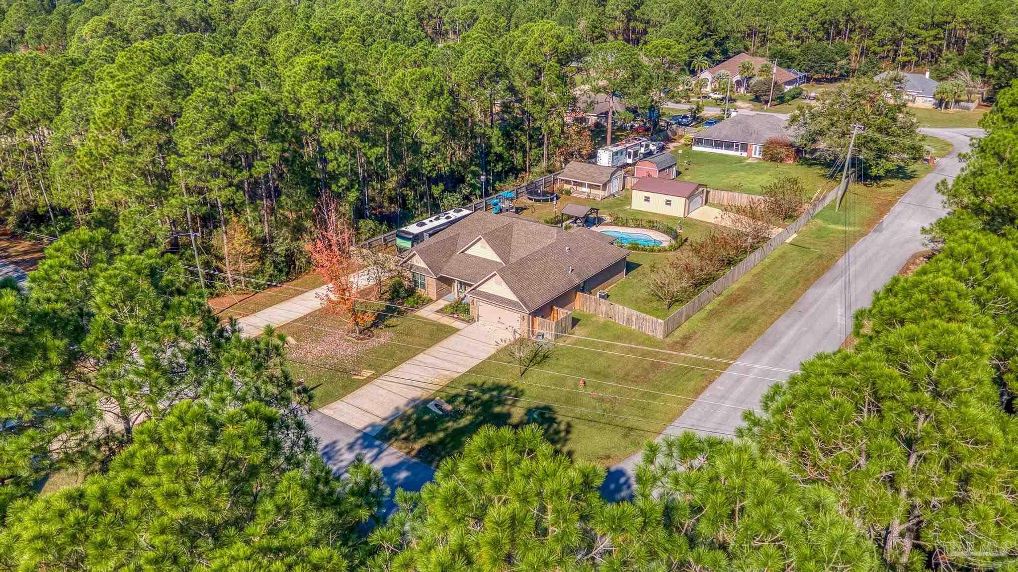 7166 Jasper Street Navarre, FL 32566 - Photo 66 of 71 an aerial view of residential house with outdoor space and trees all around
