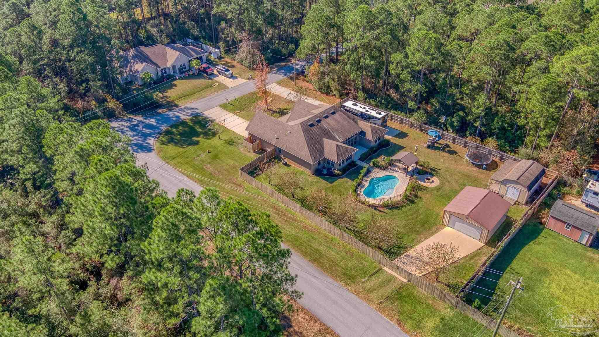 7166 Jasper Street Navarre, FL 32566 - Photo 69 of 71 an aerial view of a house with a swimming pool