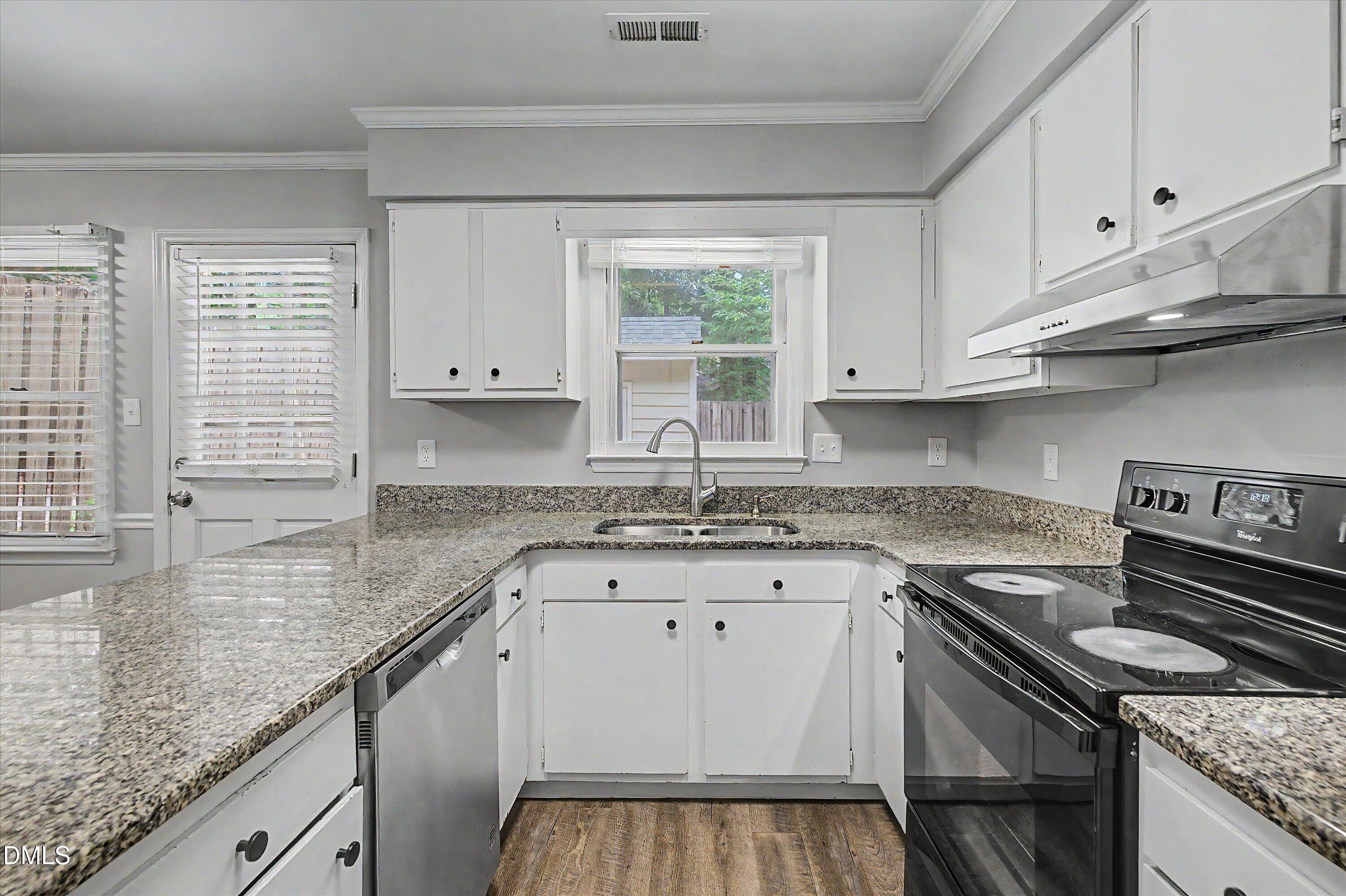 5519 Hamstead Crossing Raleigh, NC 27612 - Photo 14 of 33 a kitchen with granite countertop a sink a stove and cabinets