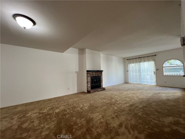 a view of empty room with a fireplace and window