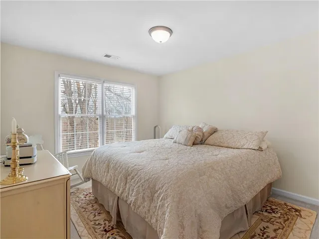 a large bed sitting in a bedroom next to a window