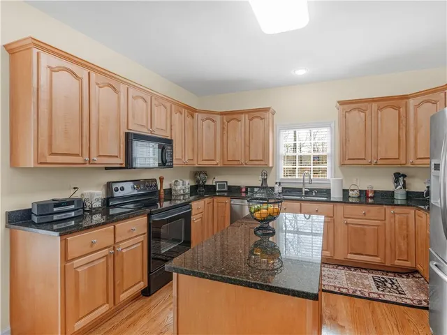 a kitchen with stainless steel appliances granite countertop a stove top oven a sink a granite counter space and cabinets