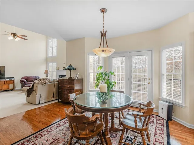 a dining room with furniture a chandelier and wooden floor