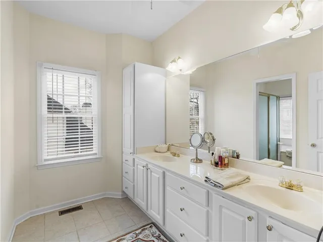 a bathroom with double vanity sinks a mirror a vanity and a window