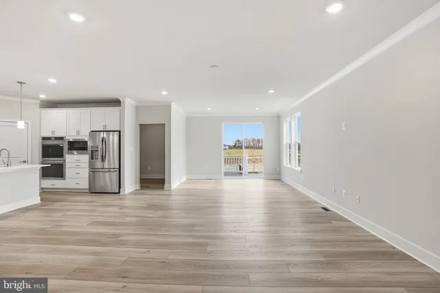 a view of kitchen with kitchen island white cabinets and stainless steel appliances