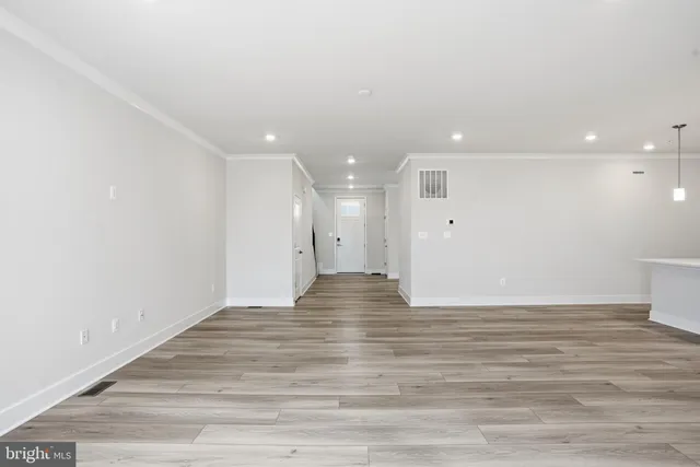 a view of an empty room with wooden floor