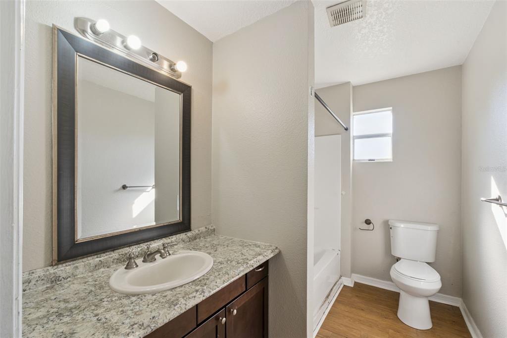 40542 West 3rd Avenue Umatilla, FL 32784 - Photo 3 of 13 a bathroom with a granite countertop sink toilet and mirror